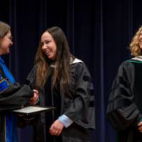 Faculty receiving award and shaking hands with Christine
